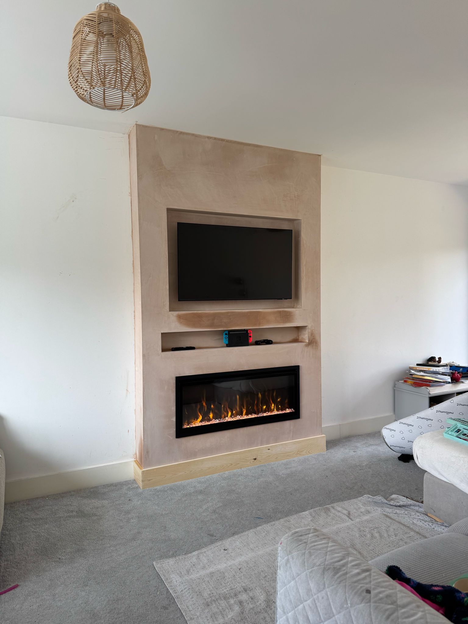 Plastered media wall with television recess, shelving and fireplace